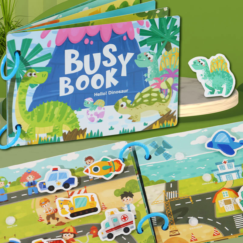 Children's busy book with dinosaur and construction theme on a green surface
