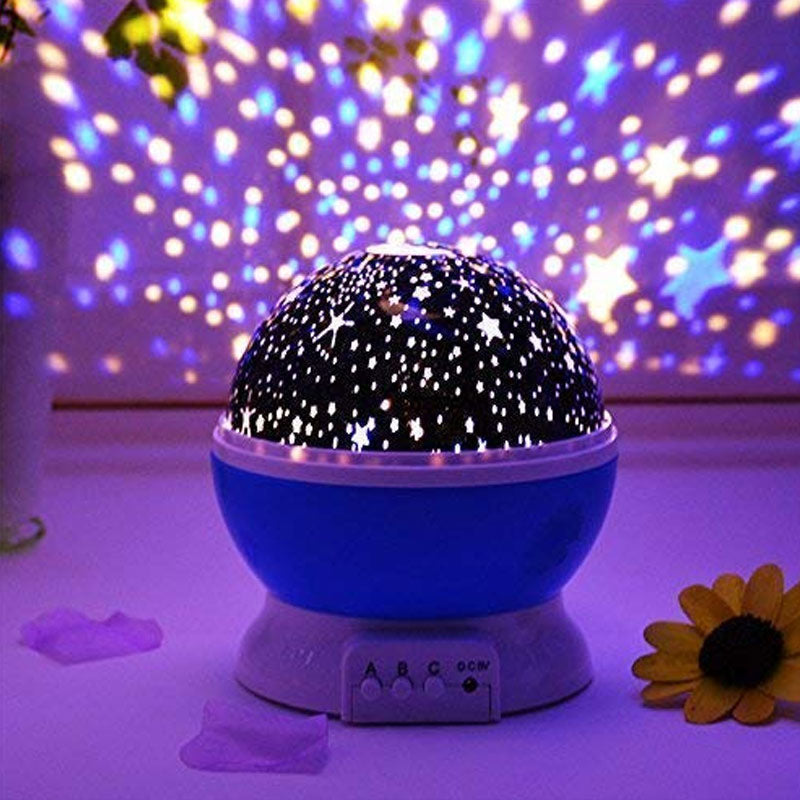 Starry night light projector with colorful light display on a blurred background